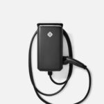 Close-up of a black power adapter with a white plug and attached cord, logo on the front.